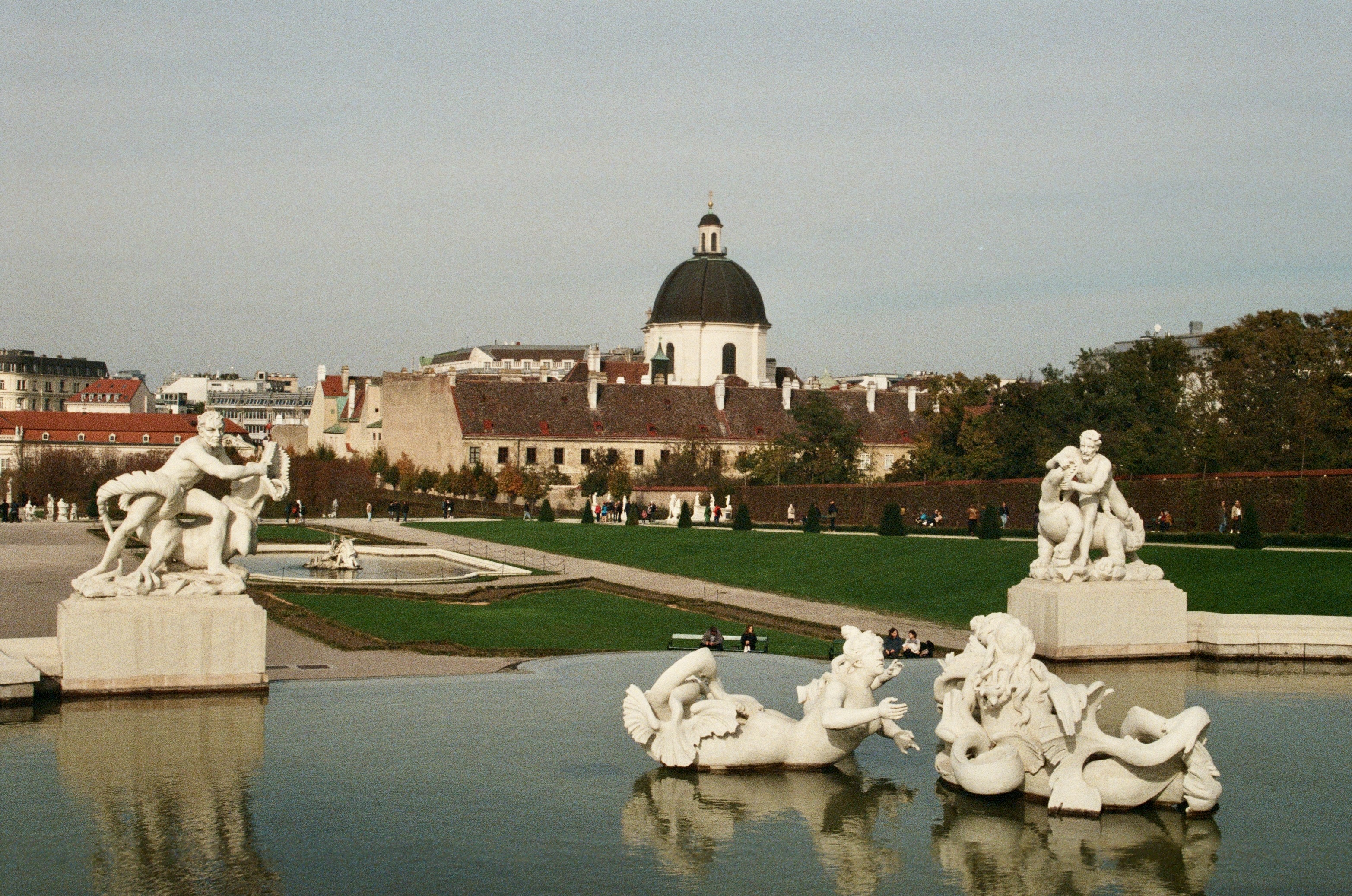 Baroque palace gardens with ornate statues and reflecting pool